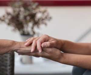 Zwei Hände halten eine andere Hand