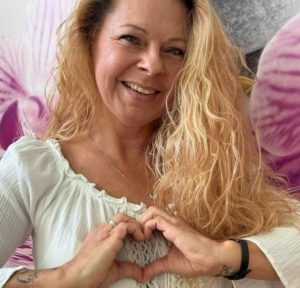 Claudia Hess formt mit ihren Händen ein Herz