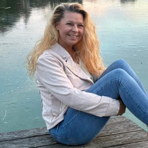 Claudia Hess sitzt auf einem See Steg